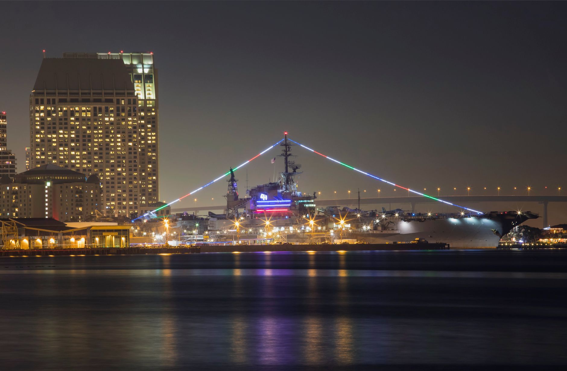 Nachtzicht van het USS Midway Museum verlicht door lasers